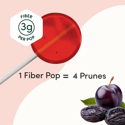 Red lollipop with fiber label and prunes on a pink background