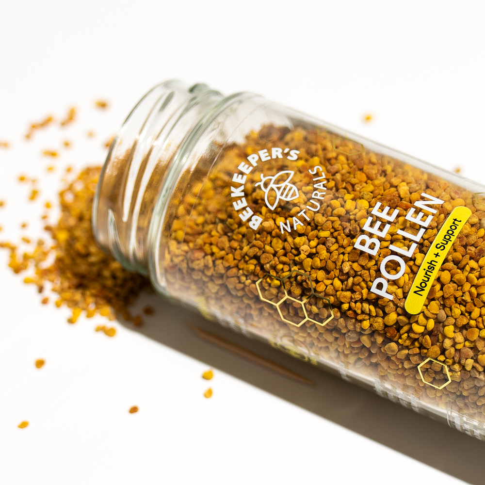 Bee Pollen jar spilling granules. "Beekeeper's Naturals BEE POLLEN Nourish + Support" label visible.