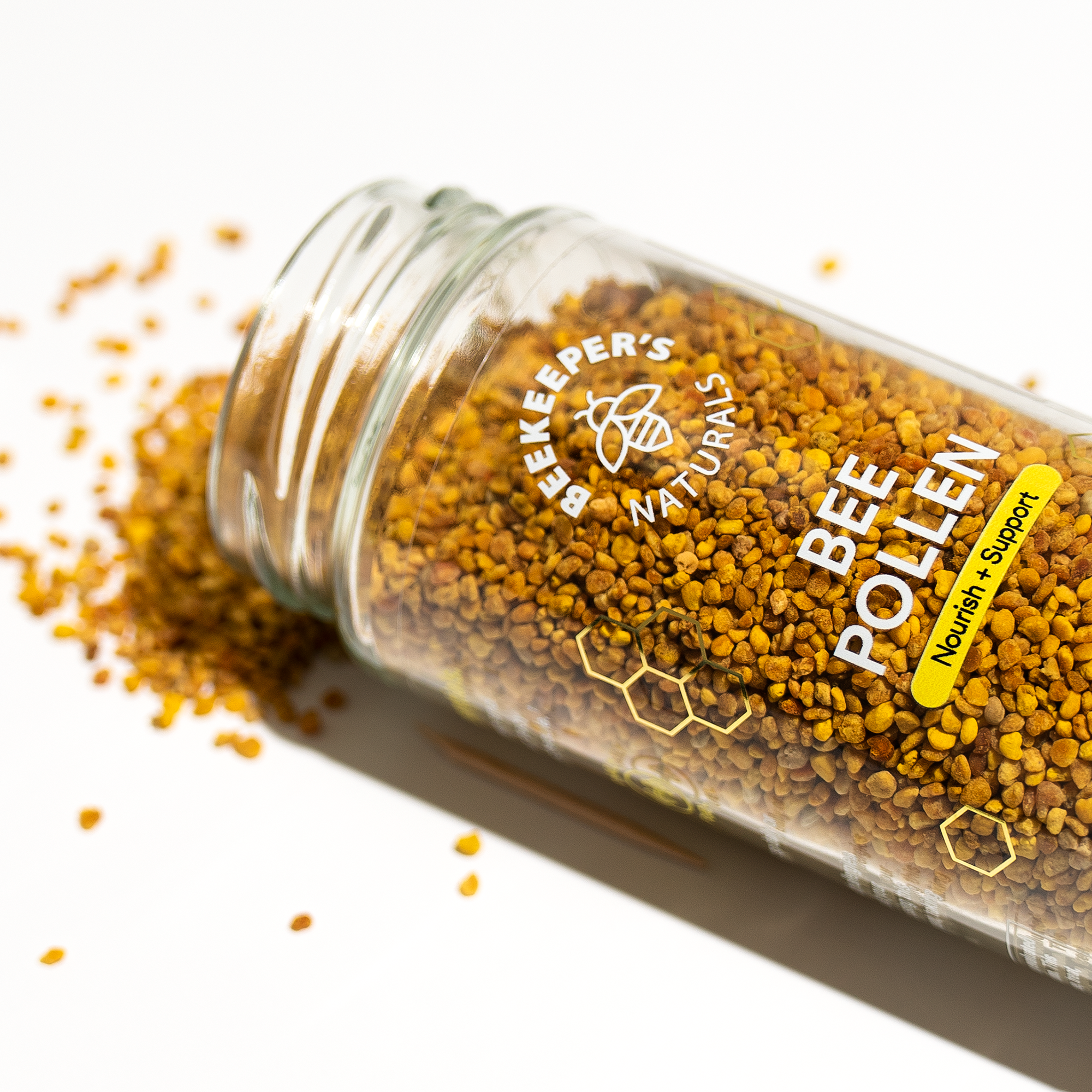 Bee Pollen jar spilling granules. "Beekeeper's Naturals BEE POLLEN Nourish + Support" label visible.