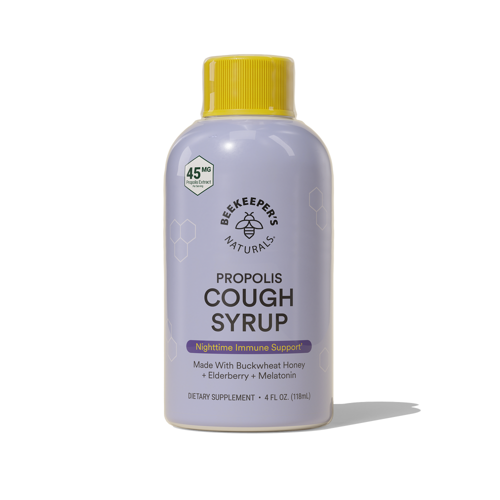 A bottle of Nighttime Propolis Cough Syrup with a yellow cap, made by Beekeeper's Naturals. The label on the bottle indicates that it is an immune support supplement made with buckwheat honey, elderberry, and melatonin.