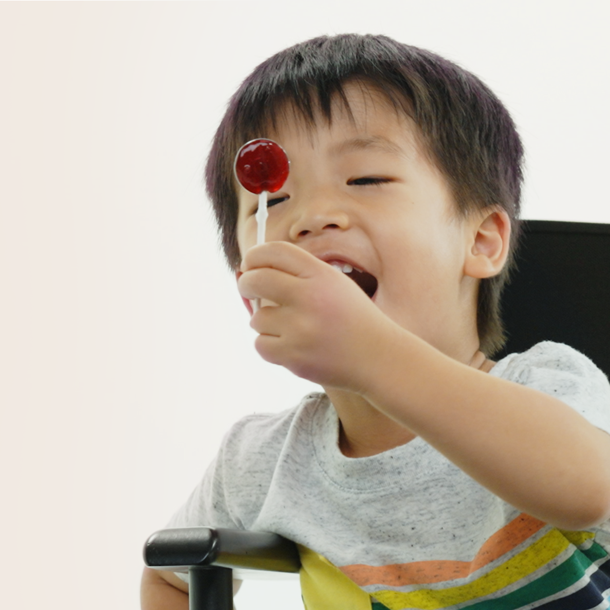 Child enjoying an elderberry lollipop, a tasty throat-soothing remedy for kids. Delicious relief!