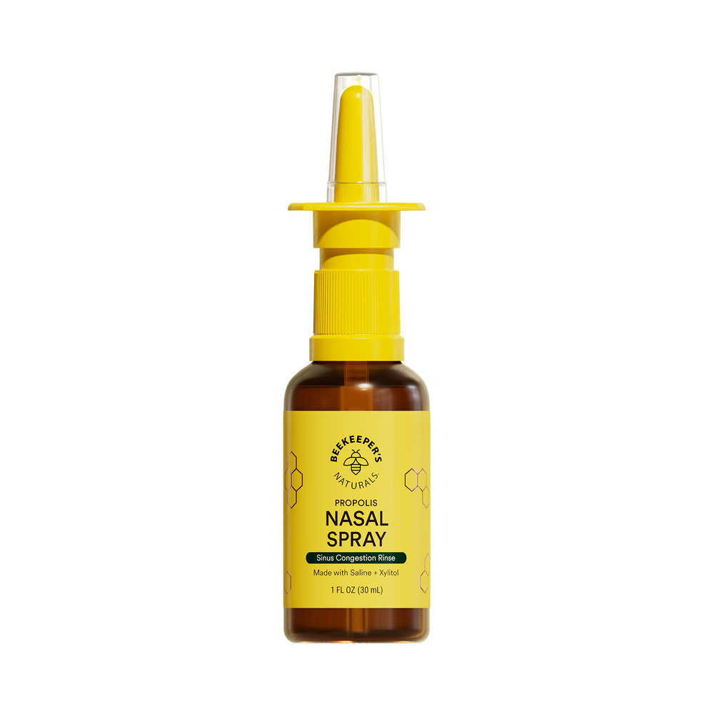 A bottle of nasal spray with a yellow nozzle and label, on a white background.