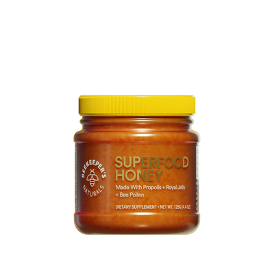 Beekeeper's Naturals Superfood Honey jar featuring propolis, royal jelly, and bee pollen. Dietary supplement.