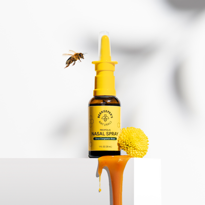 Beekeeper's Naturals Nasal Spray for sinus congestion relief, shown with a bee and honey. "Propolis Nasal Spray" on label.