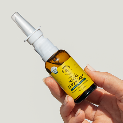 Hand holding BeeKeeper's Naturals Nasal Spray Max bottle. Contains oregano and eucalyptus for maximum sinus care.