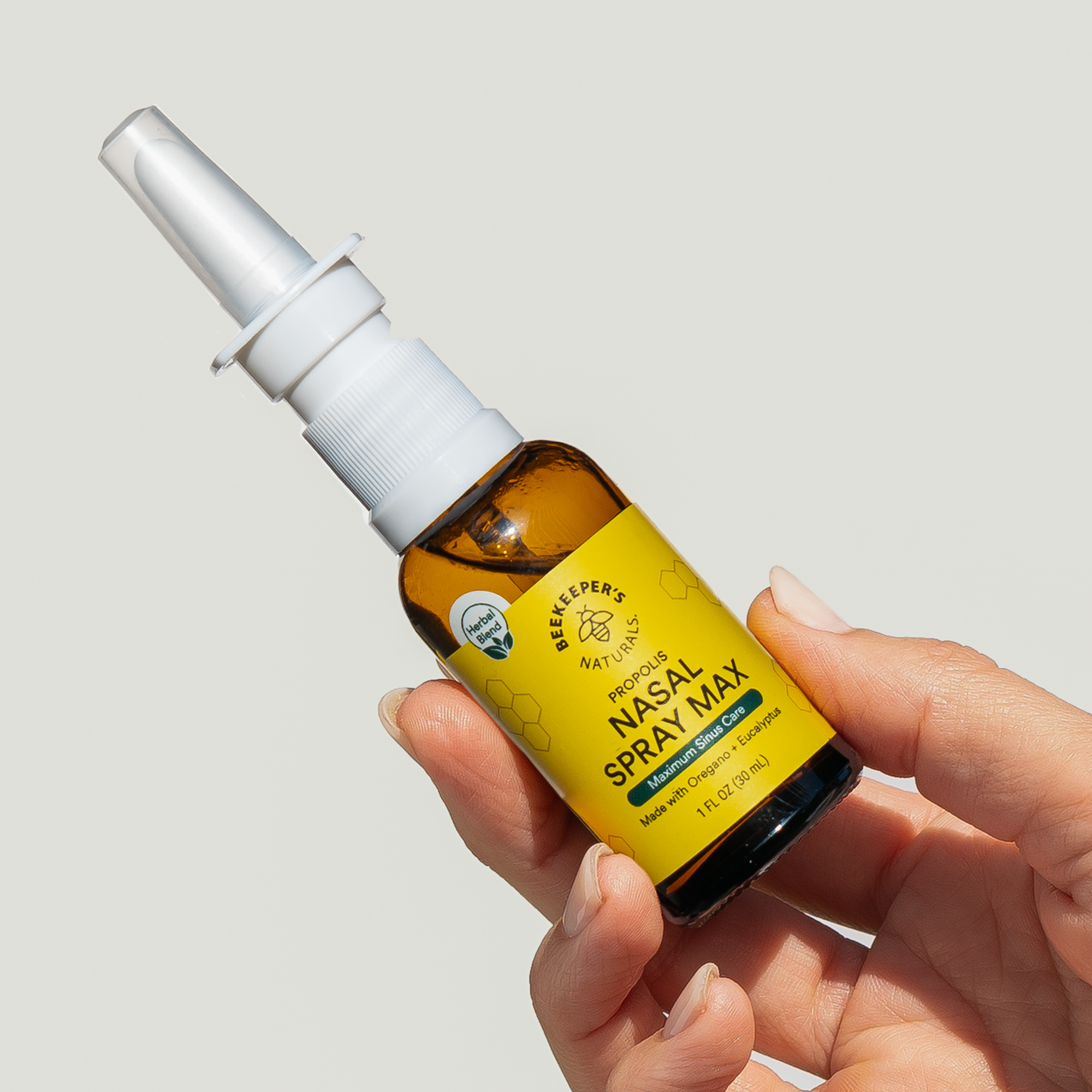Hand holding BeeKeeper's Naturals Nasal Spray Max bottle. Contains oregano and eucalyptus for maximum sinus care.