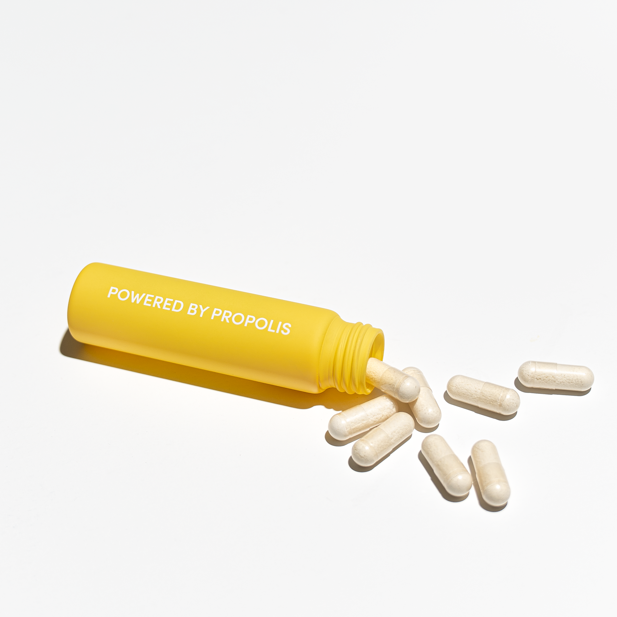 BKN Pill Tube with Propolis Capsules Spilled. "Powered by Propolis" text visible, showcasing natural supplement ingredients.