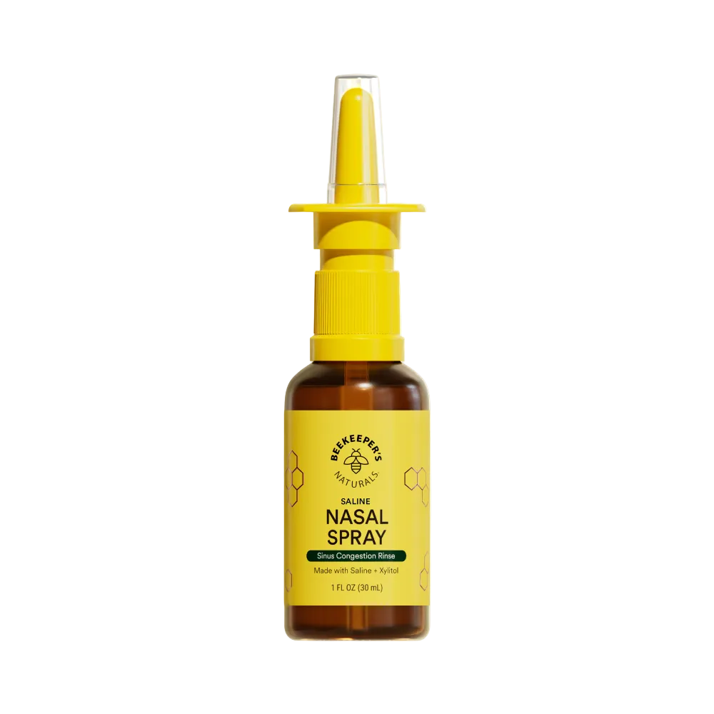 Bottle of nasal spray with yellow nozzle and label on a white background