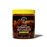 A jar of Beekeeper's Naturals Propolis Complete Gut Health supplements with capsules visible through the glass. The label is black and yellow with product information.