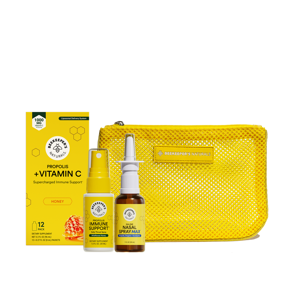 Beekeeper's Natural wellness gift set featuring a yellow mesh pouch, a box of Propolis + Vitamin C, an Immune Support spray, and a Nasal Spray Mask, all on a translucent background.