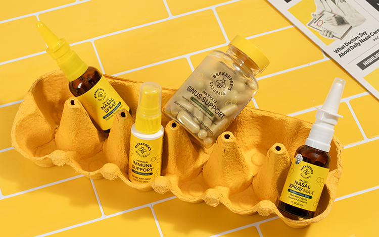 Collection of natural health products including bottles and sprays on a yellow tiled background.