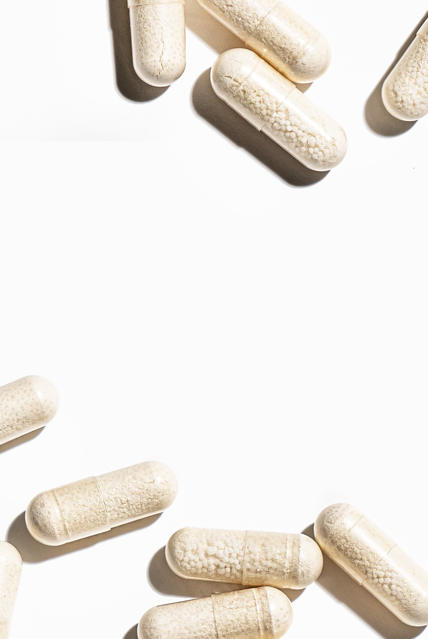 White capsules scattered on a light background