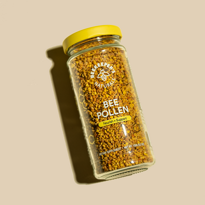 Beekeeper's Naturals bee pollen dietary supplement in a jar. "Bee Pollen, Nourish + Support" is on the label.