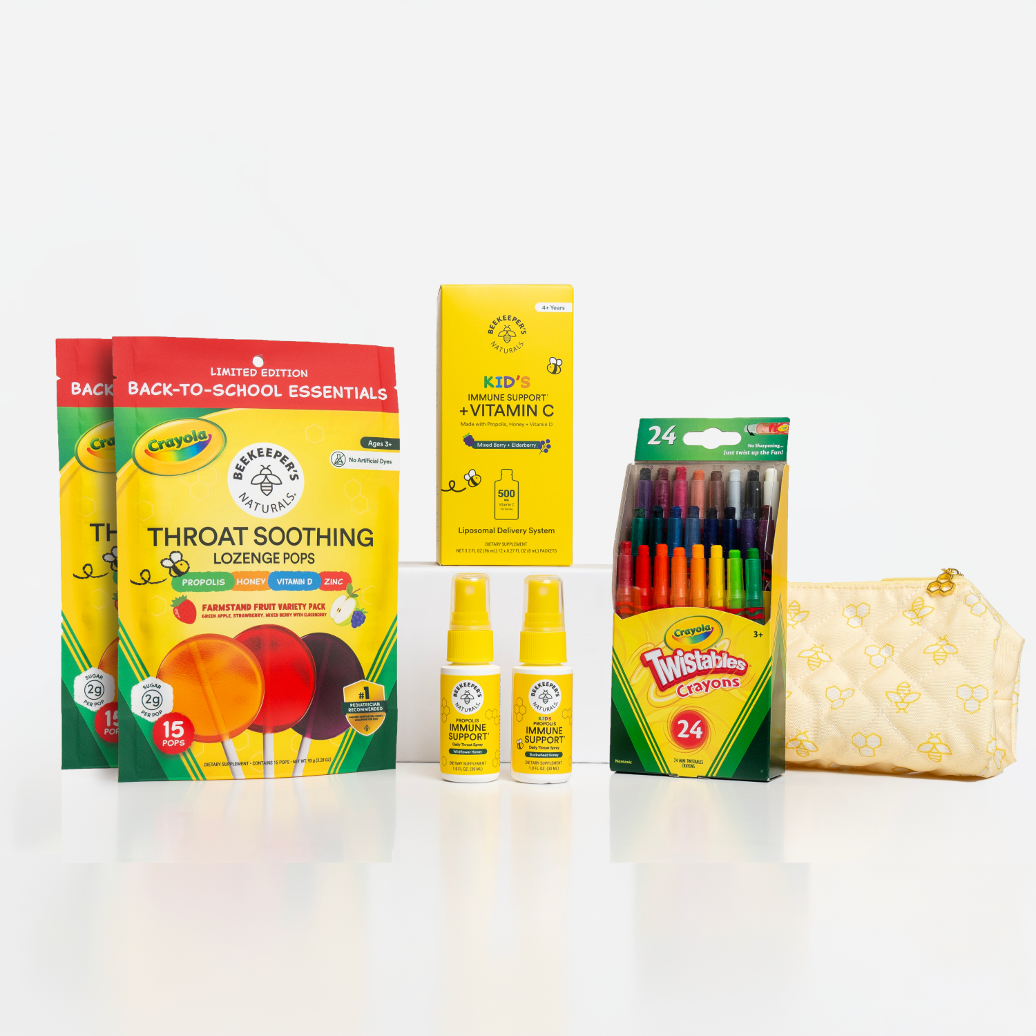 A back-to-school essentials gift set featuring two boxes of Crayola Throat Soothing Lozenges, a box of Crayola Kids Vitamin C tablets, a pack of 24 Twisted Brands markers, two small bottles of hand sanitizer, and a quilted cream zip pouch on a white background.