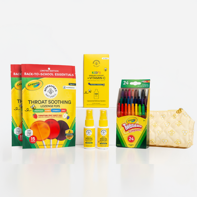 A back-to-school essentials gift set featuring two boxes of Crayola Throat Soothing Lozenges, a box of Crayola Kids Vitamin C tablets, a pack of 24 Twisted Brands markers, two small bottles of hand sanitizer, and a quilted cream zip pouch on a white background.