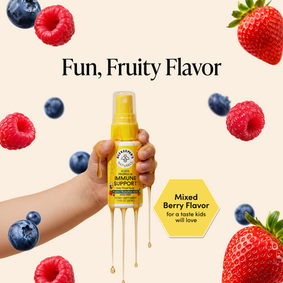 A hand holds a yellow bottle of Beaderz Immune Support syrup with honey dripping from the nozzle. The background is a light cream color with floating fresh berries and text reading 'Fun, Fruity Flavor' and 'Mixed Berry Flavor for a taste kids will love'.