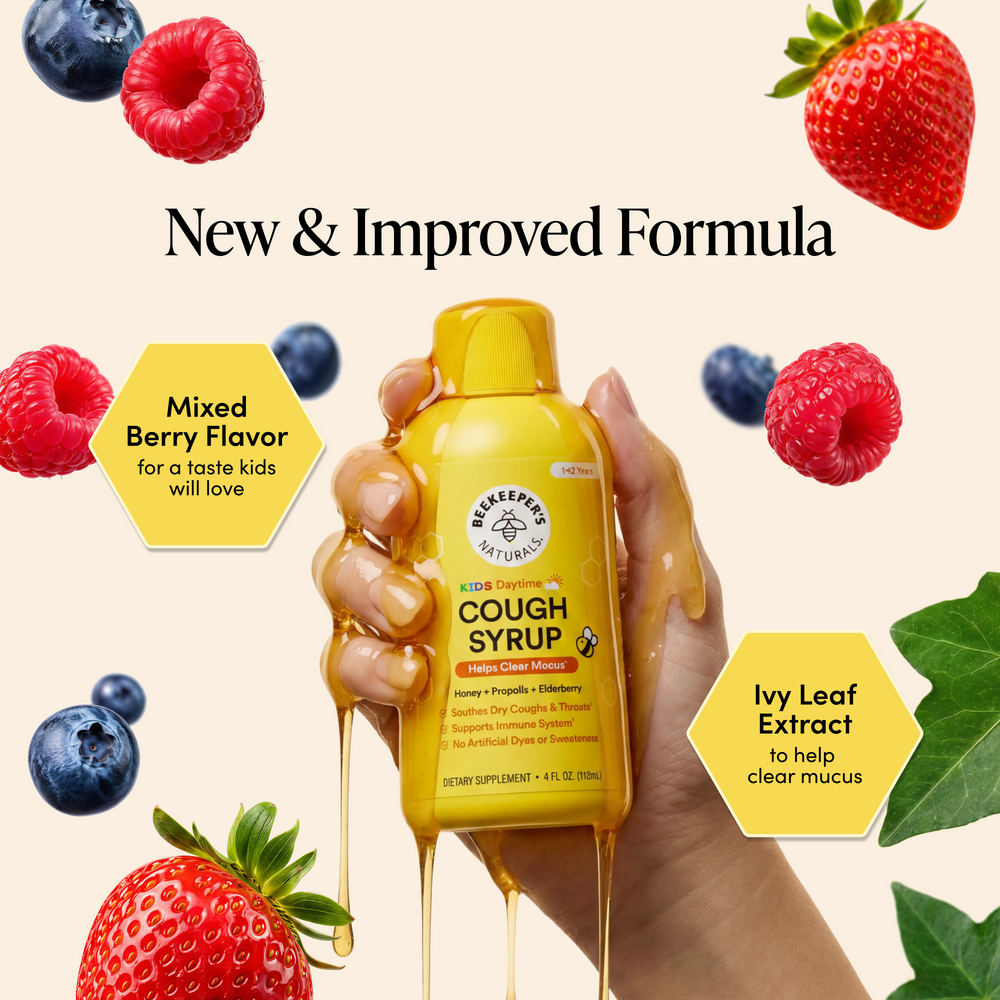 Hand holding a yellow cough syrup bottle with berries and leaves on a beige background
