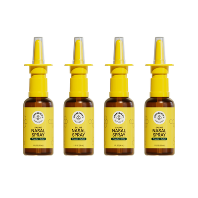 Front view of four Beekeeper's Naturals Saline Nasal Spray 1 fl oz bottles showing yellow labels and nasal applicators on white background