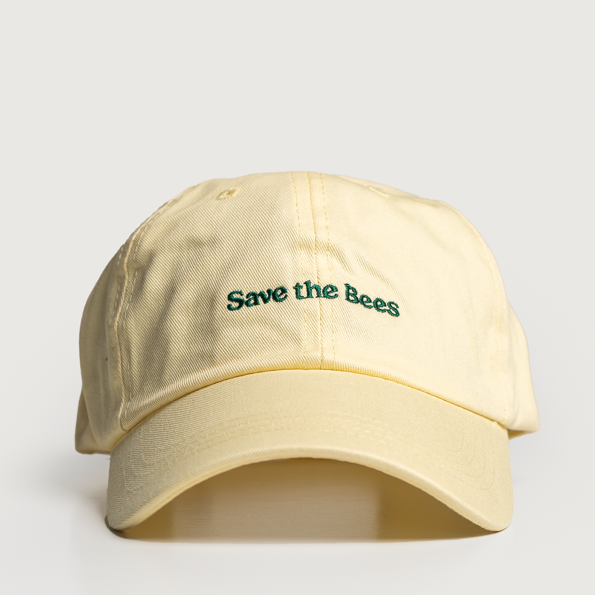 Beige cap with 'Save the Bees' text on a light gray background