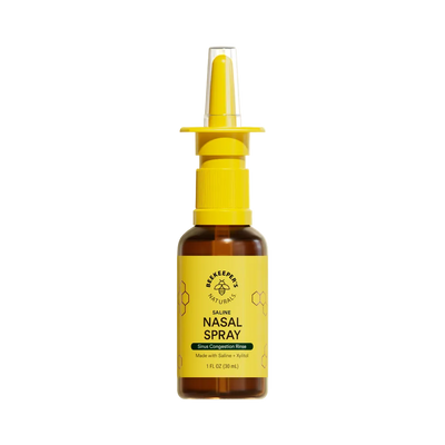Bottle of nasal spray with yellow nozzle and label on a white background