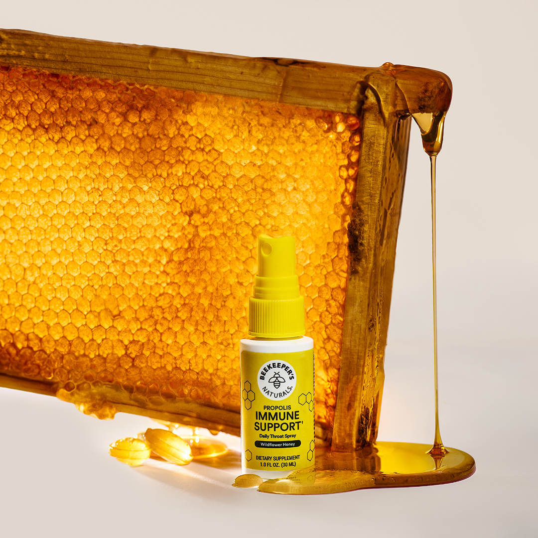 Beekeeper Naturals immune support supplement bottle with honeycomb and honey on a light background